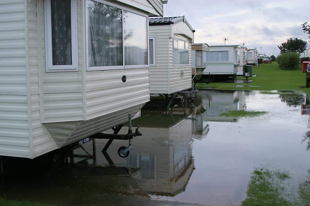 Image depicting the aftermath of heavy flooding, including a submerged caravan