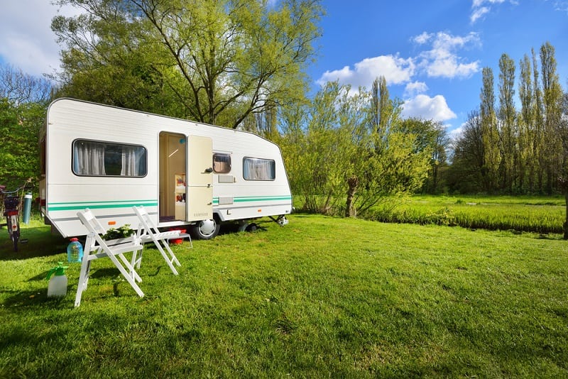 Caravan campers parked amidst nature, offering comfortable adventure base camps