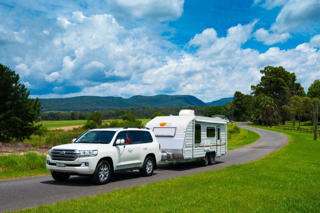 Caravan at a scenic location with a service vehicle nearby, emphasizing convenience of on-road servicing