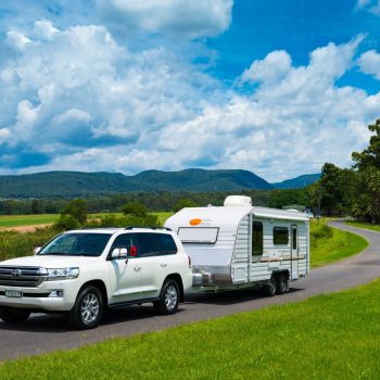 Caravan at a scenic location with a service vehicle nearby, emphasizing convenience of on-road servicing