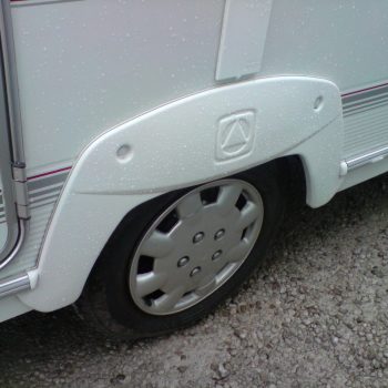 caravan wheel bearings with mounting screws, laid out on white caravan