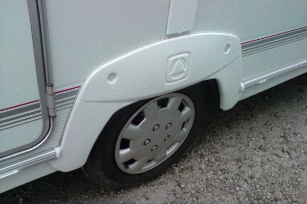 caravan wheel bearings with mounting screws, laid out on white caravan