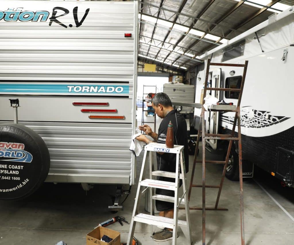 Technician inspects and repairs fibreglass on the caravan in workshop