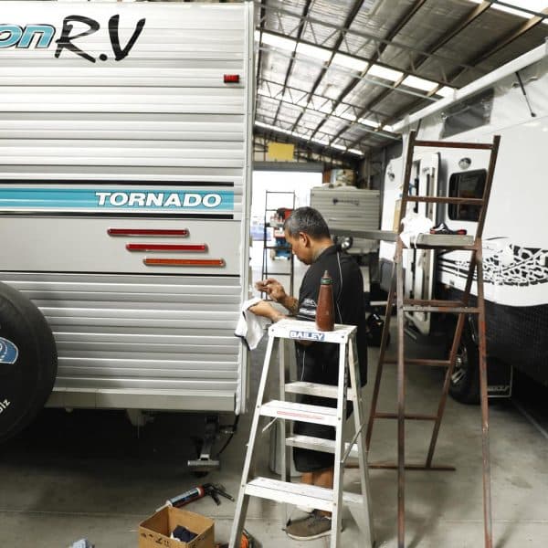 Technician inspects and repairs fibreglass on the caravan in workshop