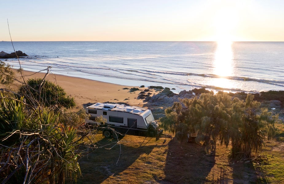 Caravan parked on a quiet beachside campsite, offering stunning ocean views