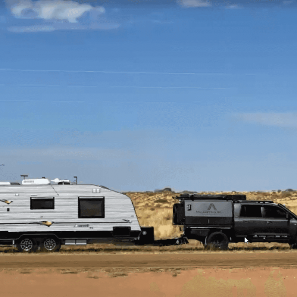 Truck towing a caravan on a dirt road, venturing into the outdoors