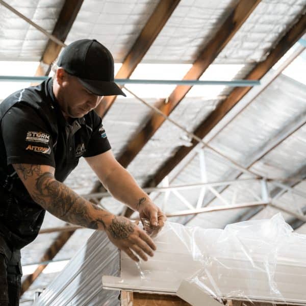 Caravan technician inspects the top of a white vehicle in a workshop