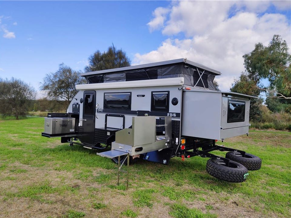 Caravan parked outdoors, featuring a mounted spare tire on the rear exterior