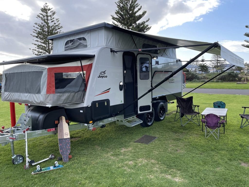 Caravan with retractable awning deployed, providing additional covered area for outdoor enjoyment