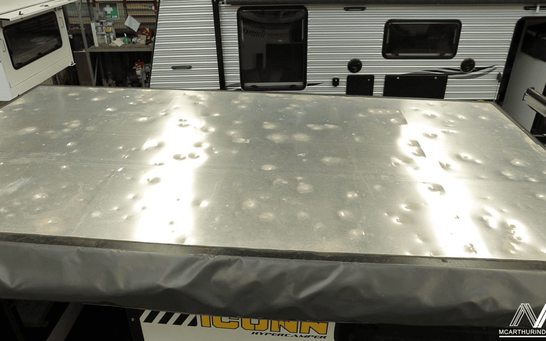 Caravan with its roof exposed, showcasing the extent of hail damage and ongoing repair work.
