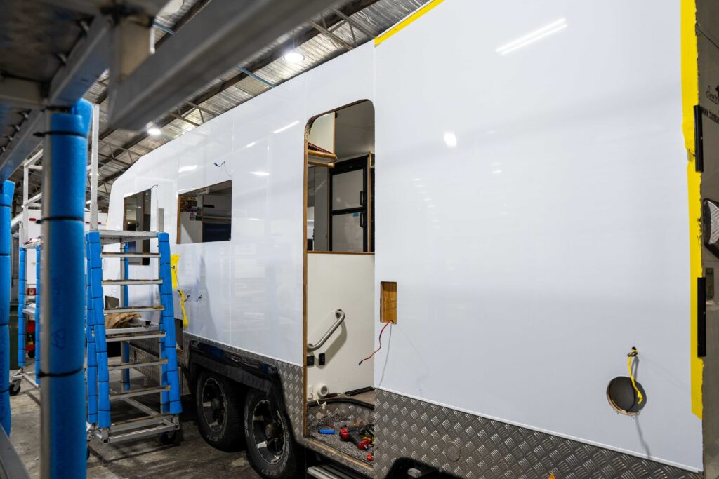 Caravan window seals being replaced with weatherproof sealant inside a specialized workshop