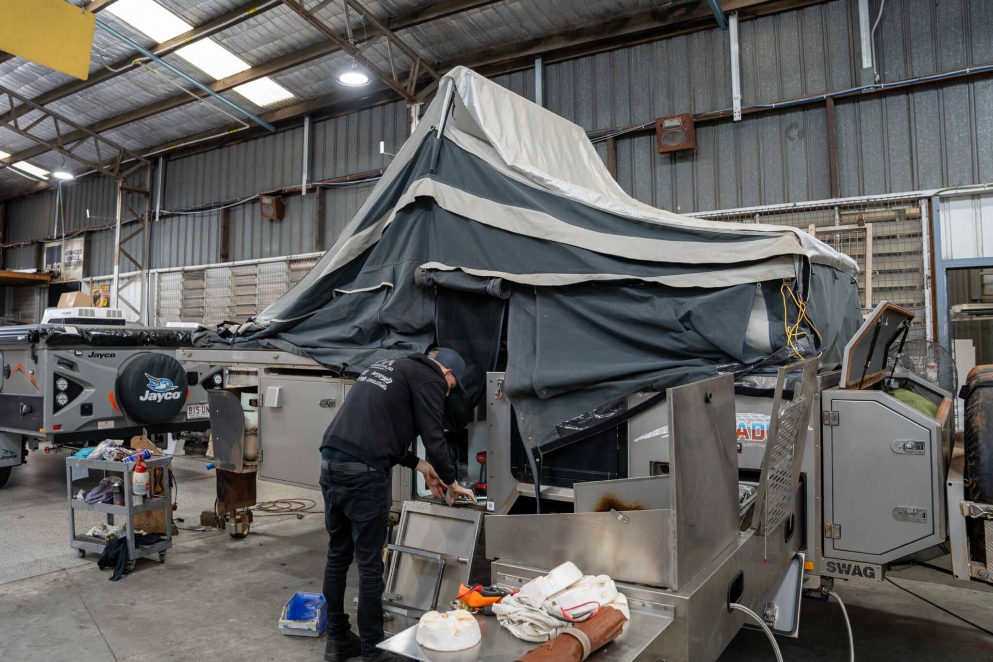 Mechanic inspecting a caravan engine during a service at a workshop