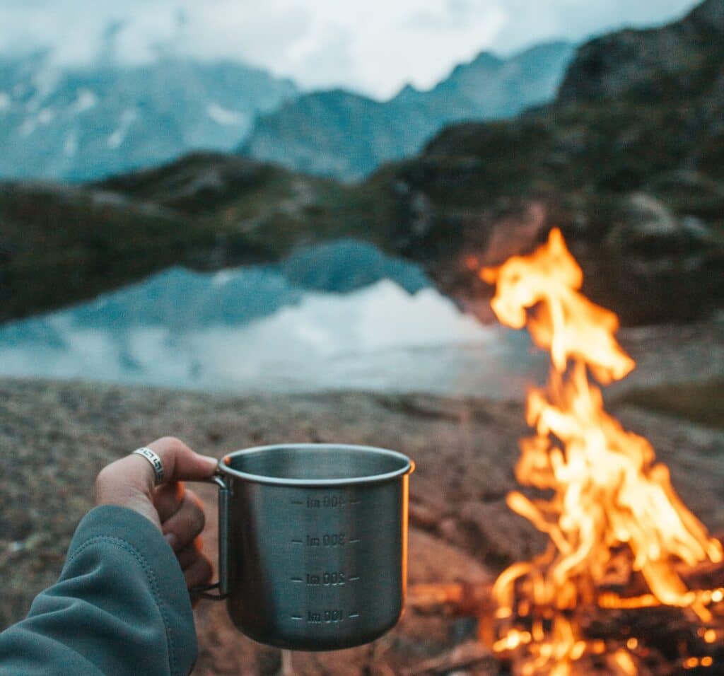 outdoors with open fire in front of a lake