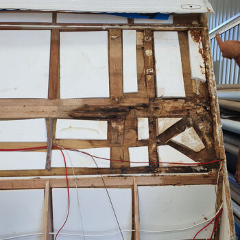 Front panel of a caravan showing significant water damage and peeling paint