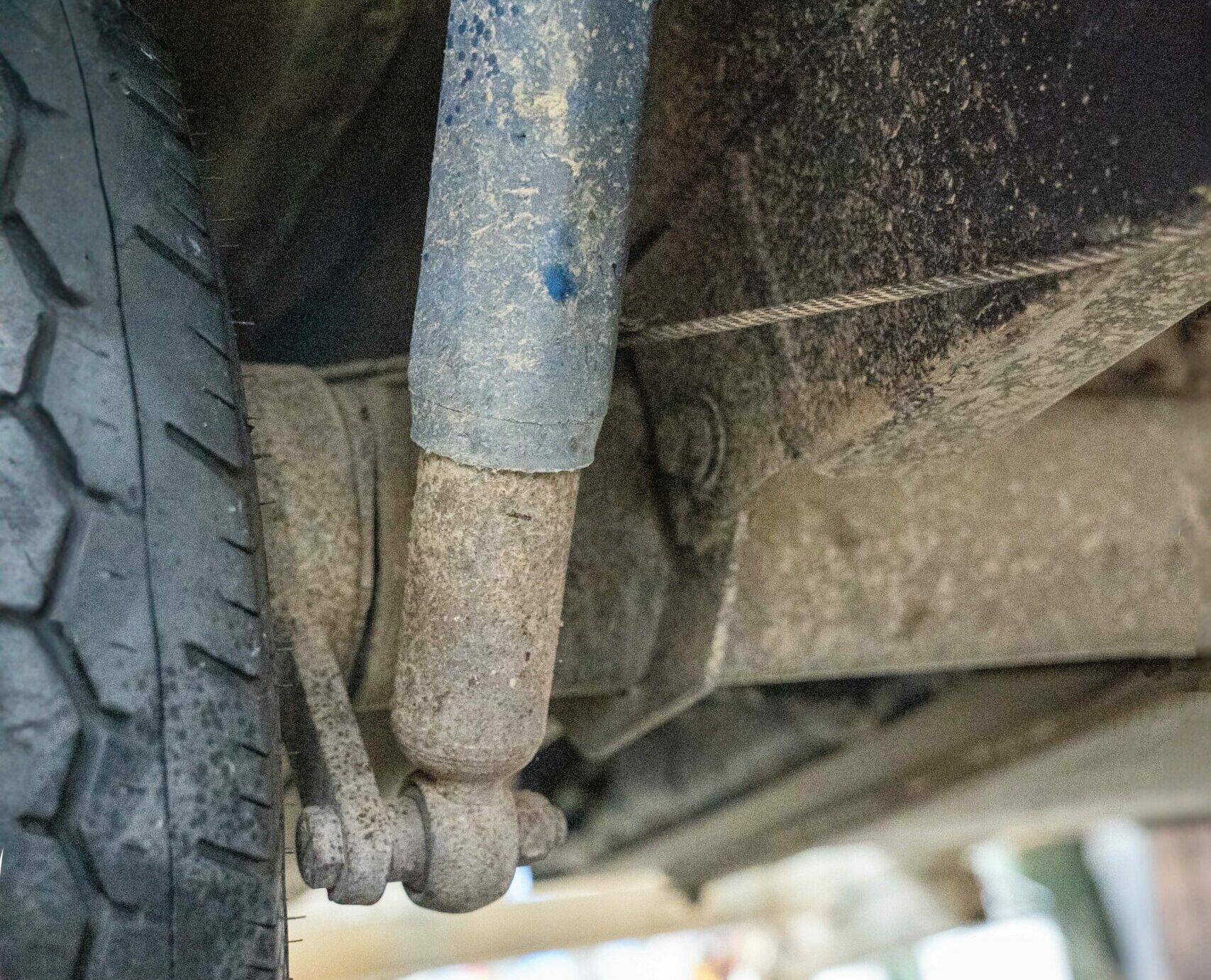 Rubber torsion axle and suspension components beneath a caravan