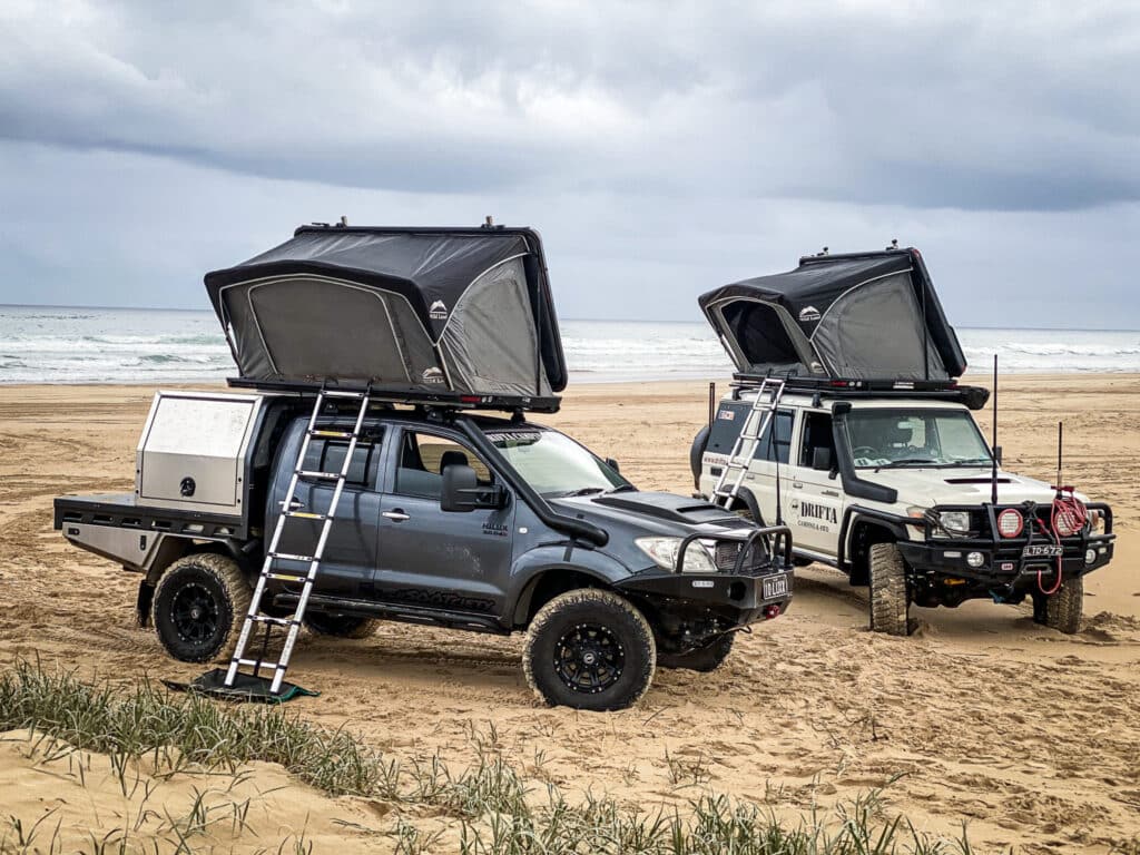 Rooftop tents perched on 4WDs, ready for a beach camping getaway