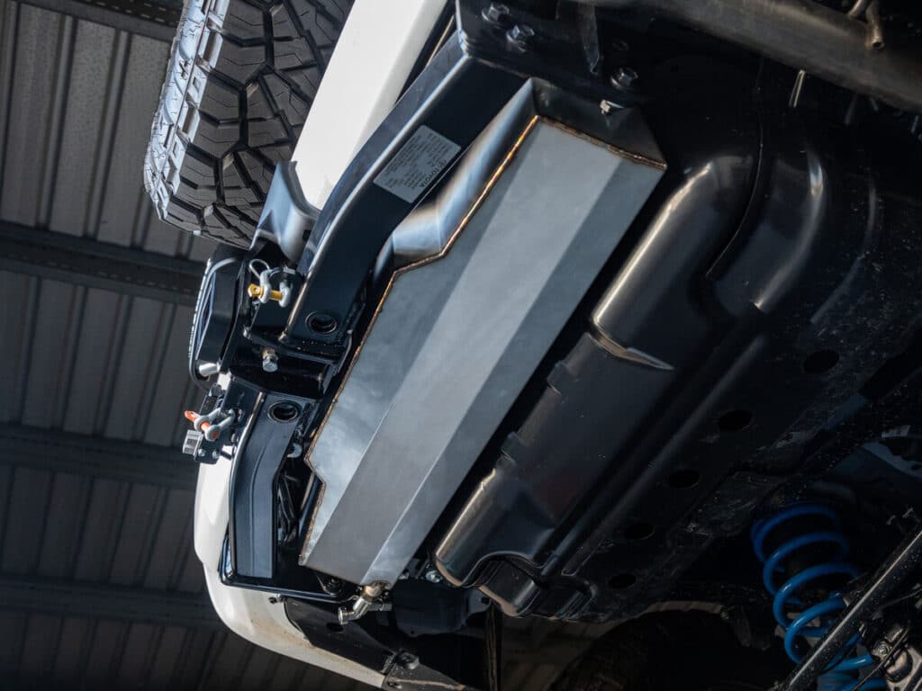 echanic examines the 4WD engine beneath the open hood in a workshop