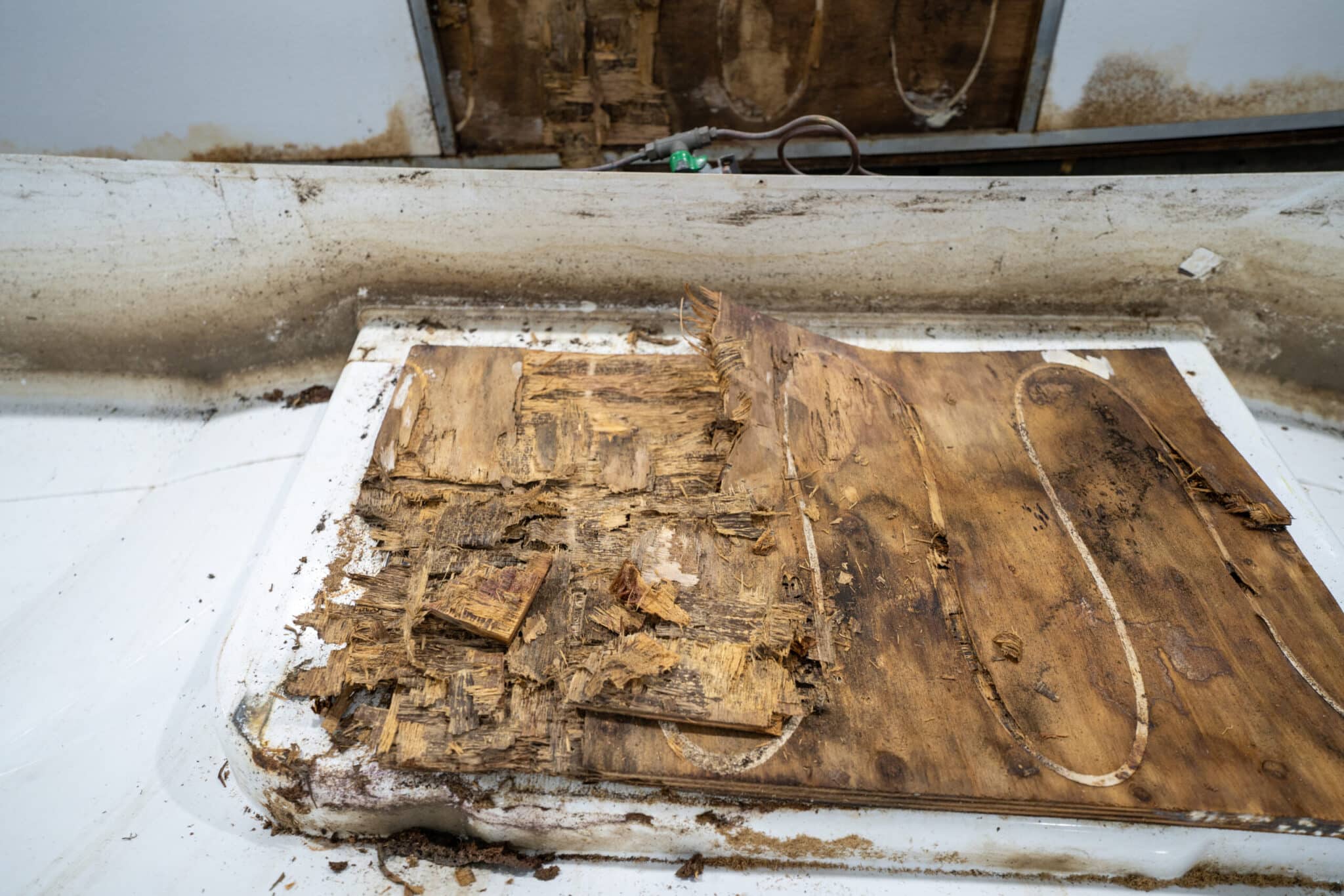 Close-up of aged caravan wood with visible wear and tear, on a white surface