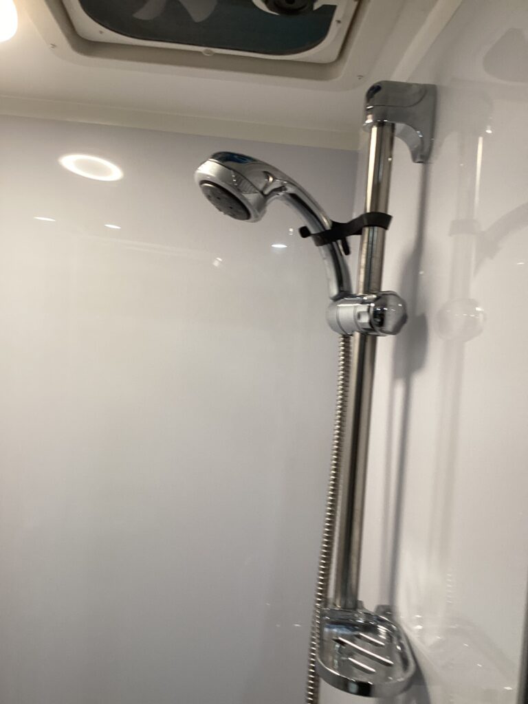 Partially installed showerhead in an unfinished caravan shower enclosure