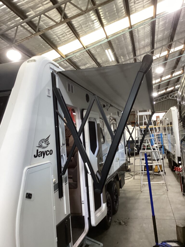 Display of various caravan awnings attached to the sides of caravans inside a shop