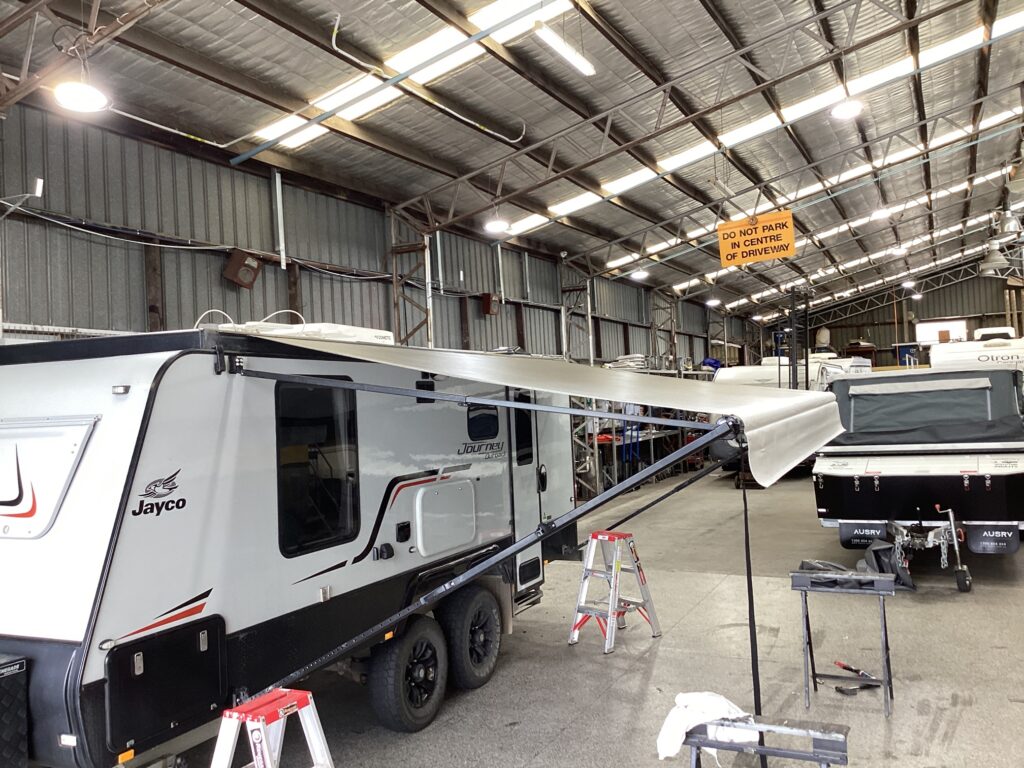 A fully extended retractable awning showcased inside a shop, demonstrating its size and functionality