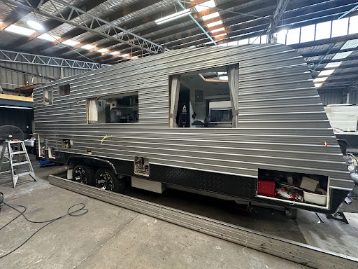 Caravan's exterior shows dents on siding and roof, needs repairs to get back on the road